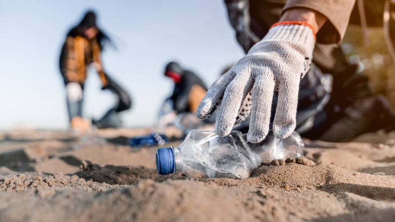 Picking up water bottle litter on the beach