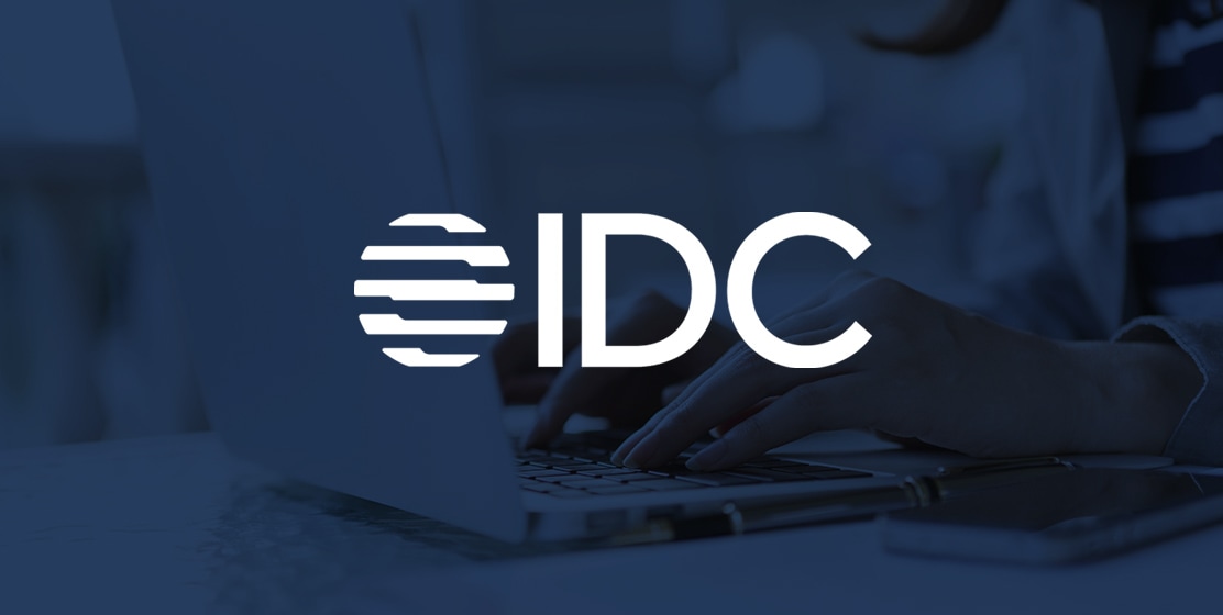 覆盖在笔记本电脑图像上的 International Data Corporation (IDC) 徽标